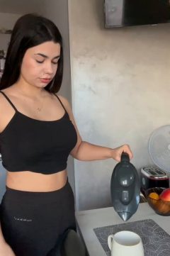 A fit, confident babe during her morning routine, teasing the camera and flashing her boobs in a casual home setting with playful attitude.