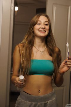 amateur girl with braless crop top brushes the the teeth in the bath