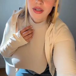 Curvy girl in a denim mini skirt and tight braless top dancing and bouncing in her living room.