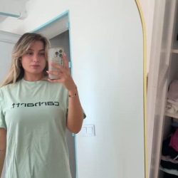 Hot amateur girl in black panties recording a homemade video selfie, revealing her nice boobs under a braless blouse in high-quality NSFW.