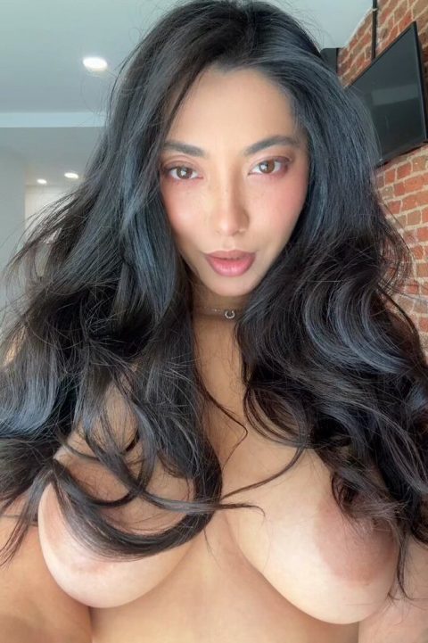 Exotic busty beauty with long dark hair performing a nude TikTok dance in a high-quality NSFW homemade video selfie.