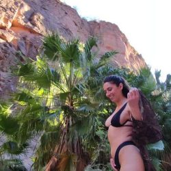Sexy fit girlfriend on vacation outdoors, pulling down her black swimsuit to reveal her big natural tits in a high-quality NSFW short clip.