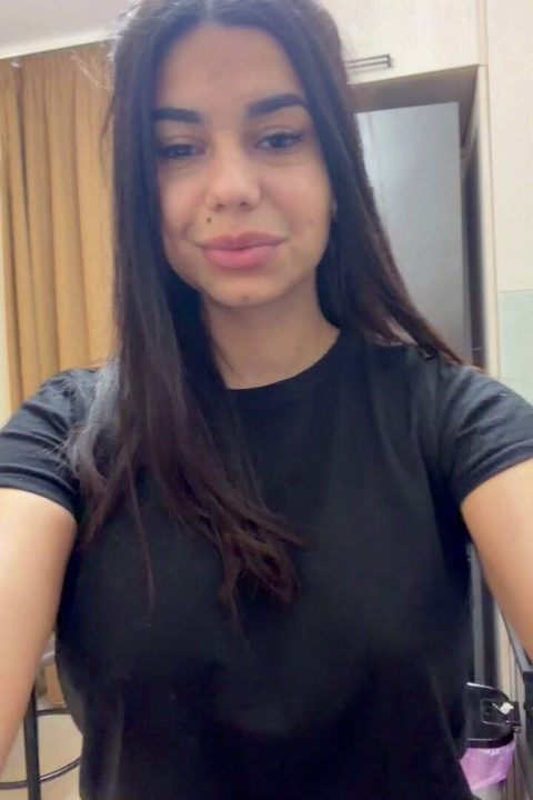Sexy young amateur brunette smiling as she takes the viral on/off challenge, transitioning from a tight black outfit to completely naked.