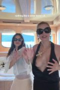 Famous American model and television personality wearing an ultra-revealing plunging black dress and oversized dark sunglasses while dancing outdoors on a luxury yacht-pic 3