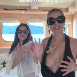 Famous American model and television personality wearing an ultra-revealing plunging black dress and oversized dark sunglasses while dancing outdoors on a luxury yacht-pic 3