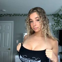 Cute teen curly girl slowly revealing big natural boobs from braless strapless top at home