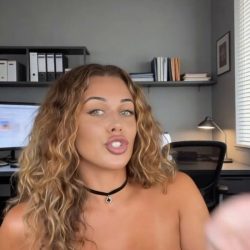 Topless woman with large breasts and pierced nipples talking on camera